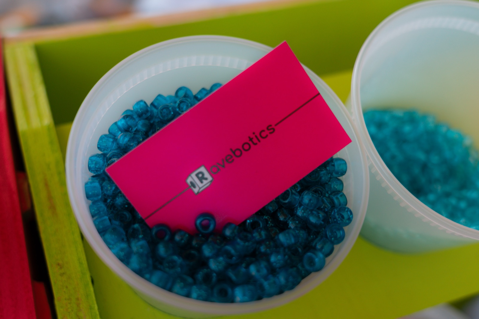 a Ravebotics business card in a jar of beads