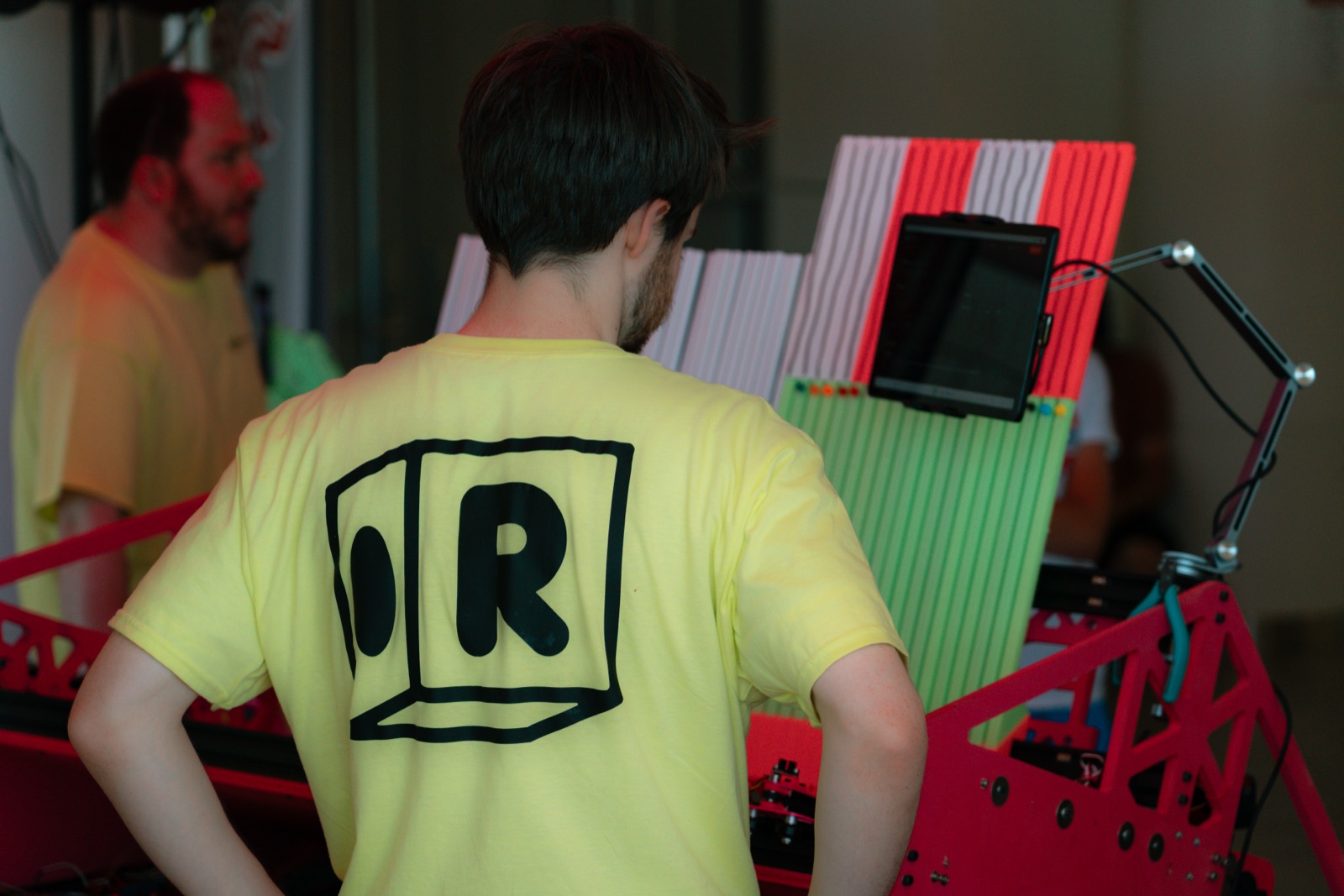 the Caffeine robot stringing bracelets at the booth